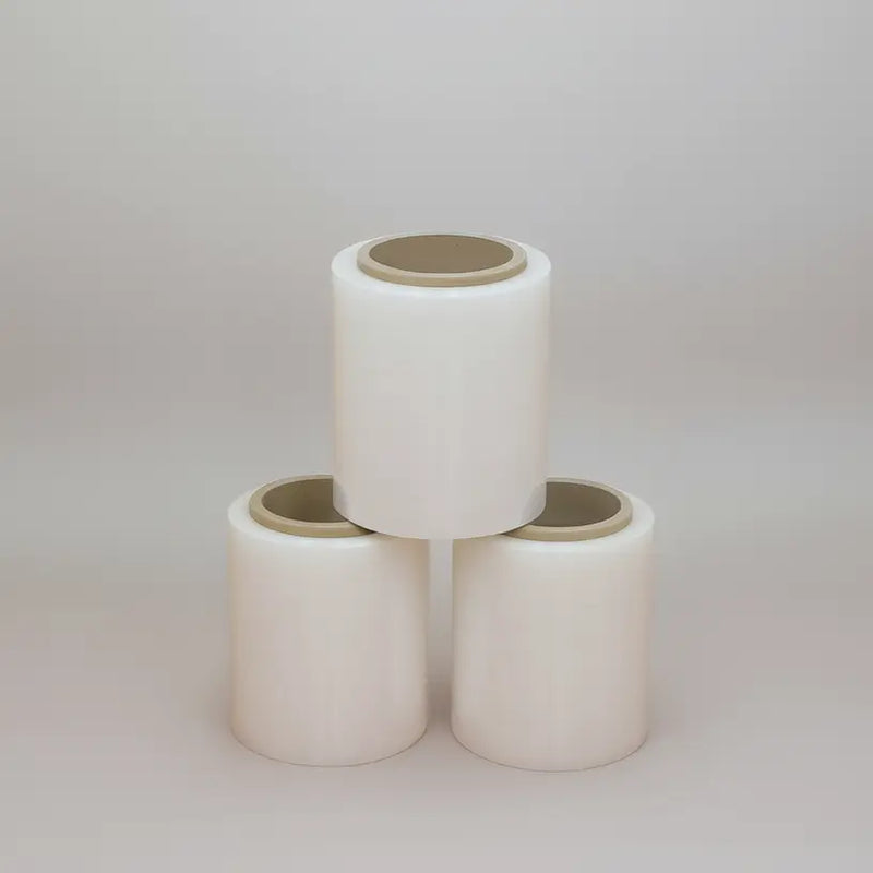 Three cylindrical ceramic planters stacked on a light gray background